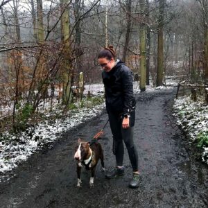 Sarah avec son chien dans les bois en tenue de canicross