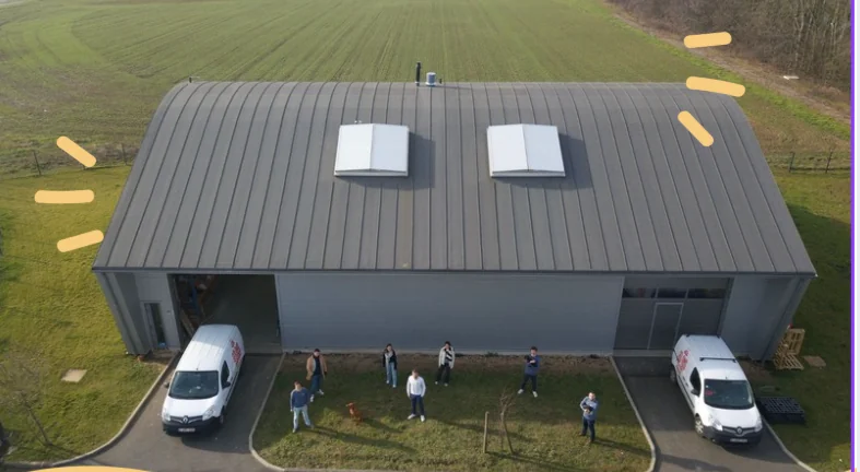 L'atelier de Colonel Gustave à Andenne, vu d'en haut, avec l'équipe devant le bâtiment